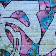 Bild på Fragment of graffiti drawings The old wall decorated with paint stains in the style of street art culture Colored background texture in purple tones